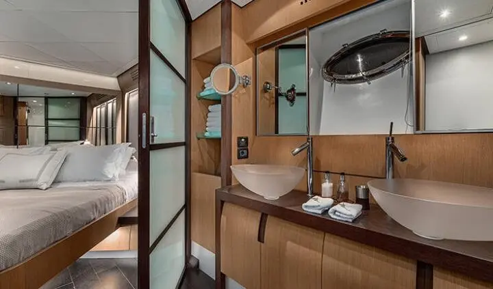King bed in a yacht cabin with wood paneling, ensuite, and compact seating