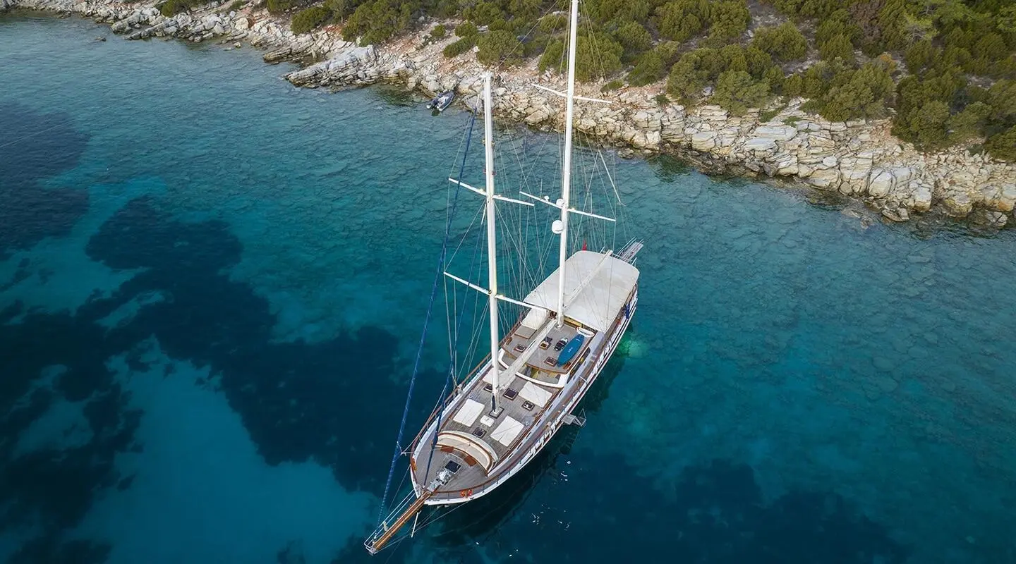 Aerial view of Artemis yacht anchored near rocky coastline with turquoise water