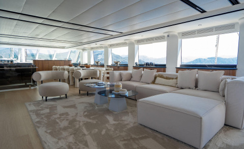 Luxurious De Love yacht interior living area with white sofa and tables