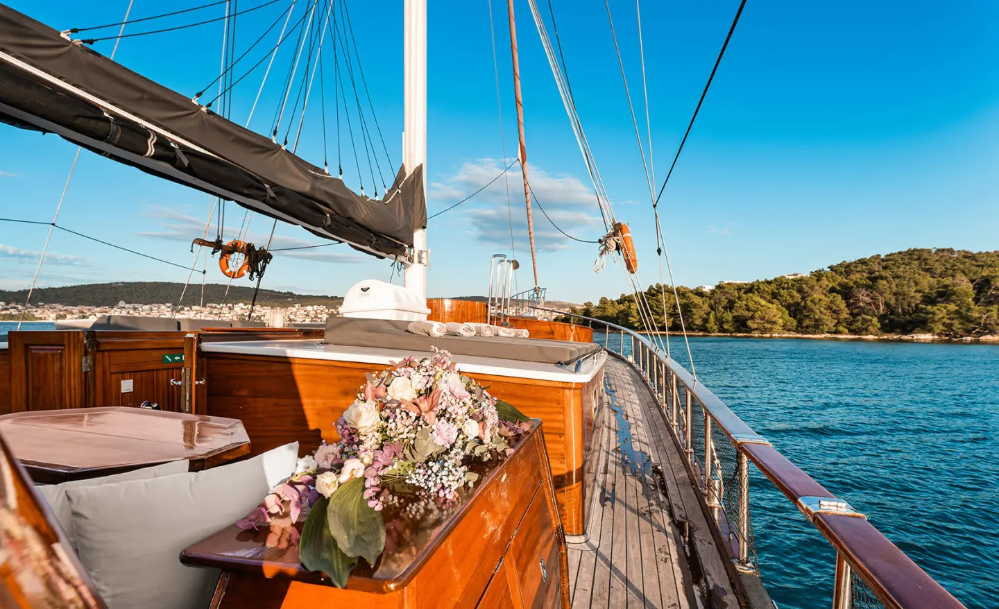 Croatia yacht exterior deck with polished wood, bouquet centerpiece, and blue sea