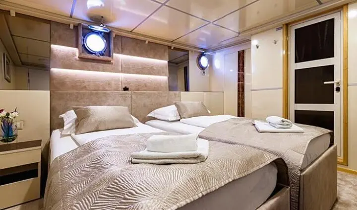 Twin cabin on Melody yacht: two single beds with beige bedding and wood tones