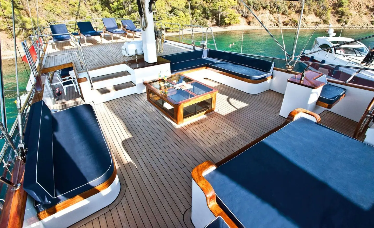 Open deck with navy cushions and wooden flooring on a yacht