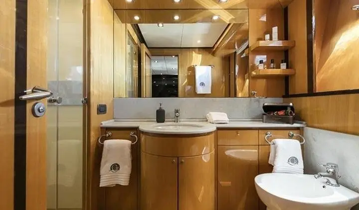 Master cabin with king bed, wood cabinets, ensuite bathroom visible