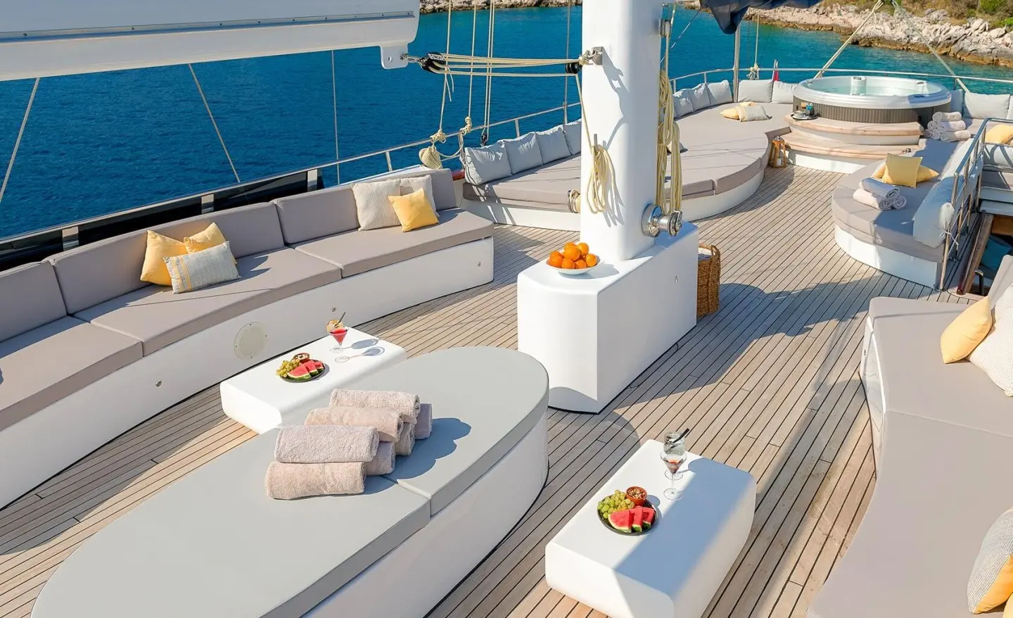 Lady Gita yacht deck with sun loungers, cushions, and a white shaded dining area