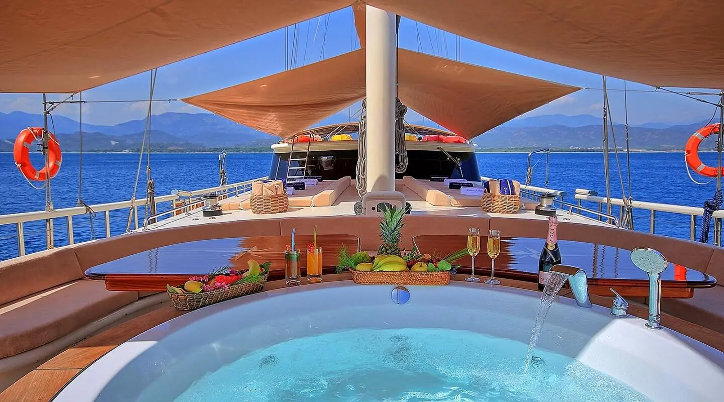 View from pool deck of Queen Of Salmakis gulet with people lounging on deck chairs