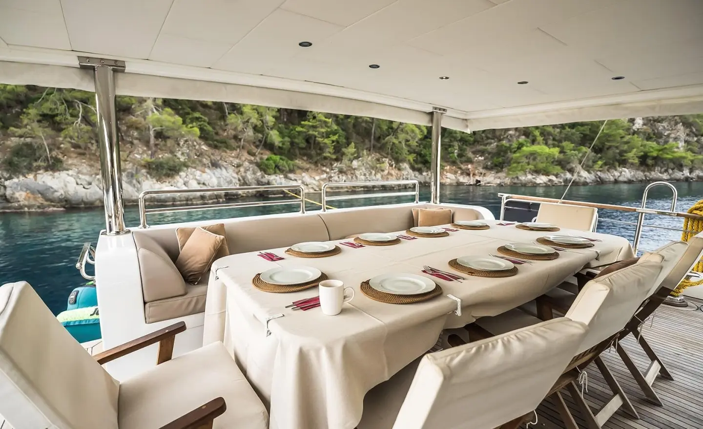 Belgin Sultan yacht charter: exterior seating on deck at sunset with white tablecloths
