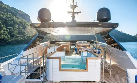 Morning Star yacht deck with pool, sun loungers, and blue seating under clear sky