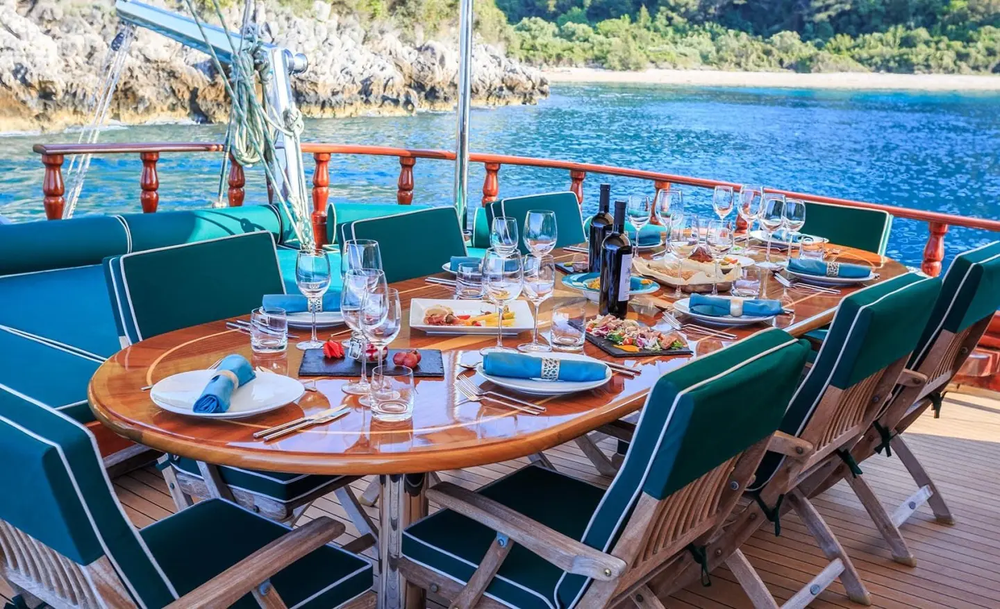 Carpe Diem 7 yacht dining setup on deck at sunset with table settings