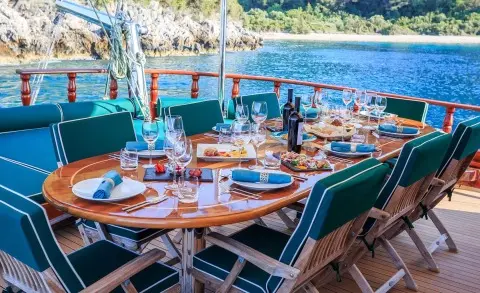 Carpe Diem 7 yacht dining setup on deck at sunset with table settings