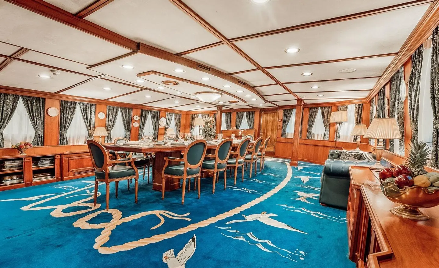 Seagull II dining room aboard yacht with wooden chairs along polished table