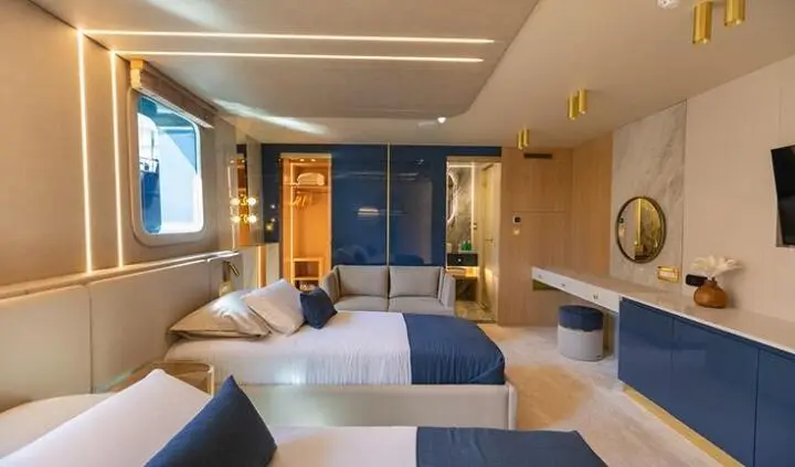 Master cabin featuring a large bed with blue accents and ensuite area