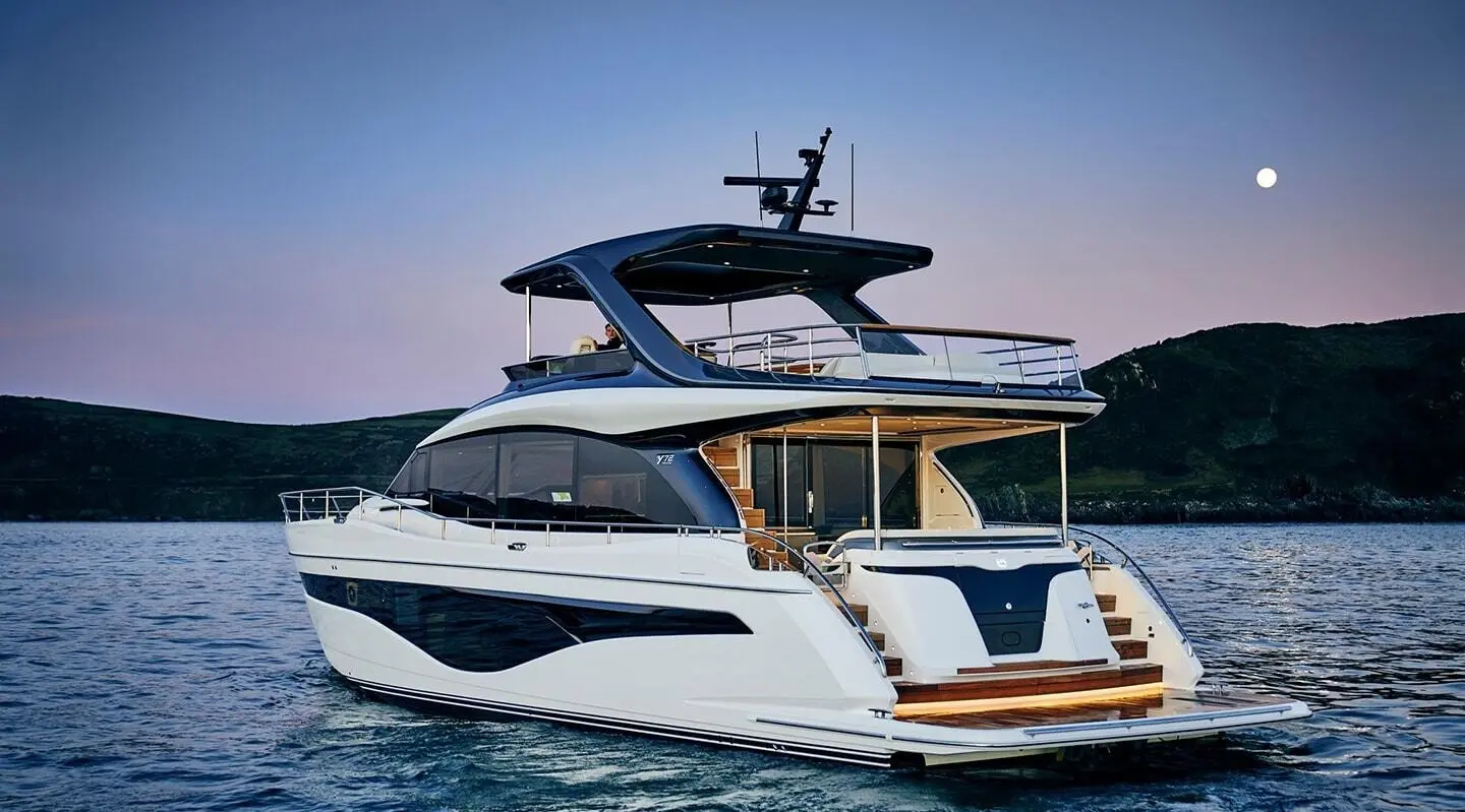 Luxurious motor yacht Elizabeth cruising on calm blue water with clear sky