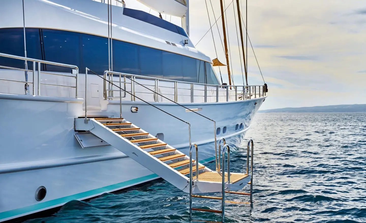 Acapella yacht docked at sunset with wooden gangway leading to deck