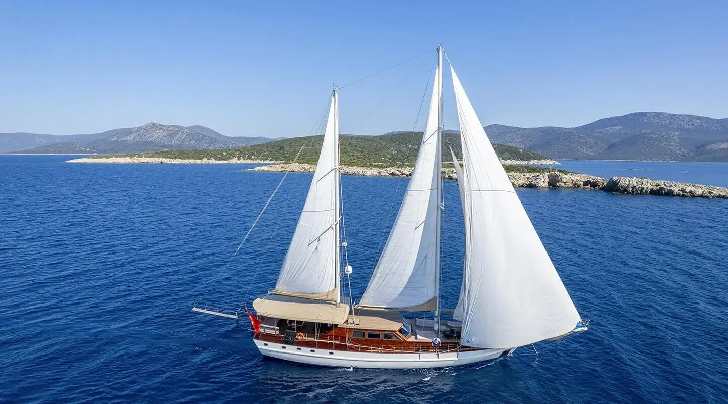 Yacht Arabella gulet sails on blue sea with clear horizon and coastline