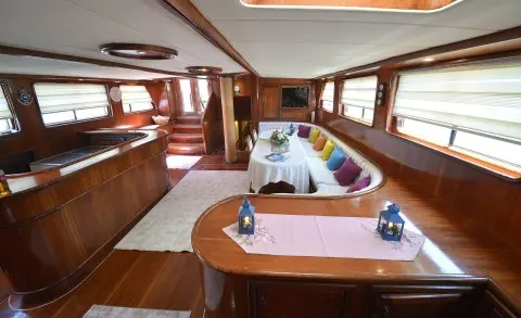 Interior of Prenses Bugce luxury gulet with wooden seating and dining area