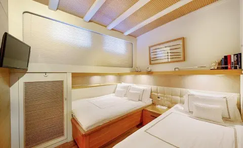 Cobra King yacht interior with twin beds, wood accents, porthole light