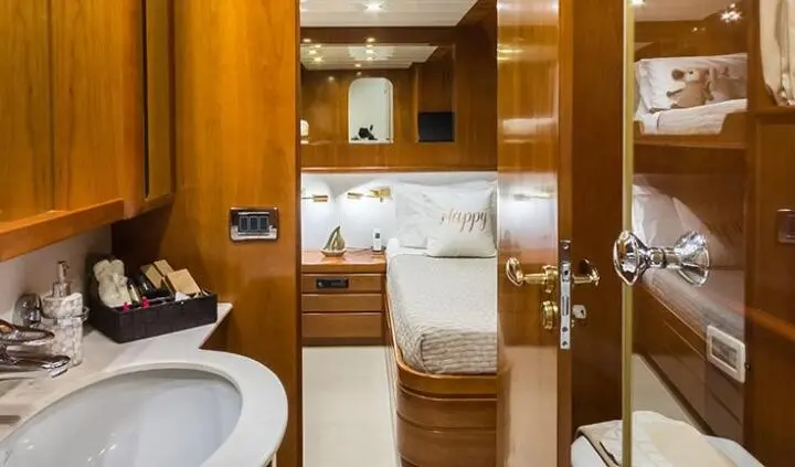 Master cabin with king bed, wood cabinetry, ensuite bath visible