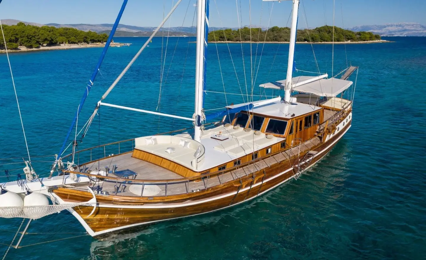 Andi Star yacht deck with white seating and wooden cabin on blue sea