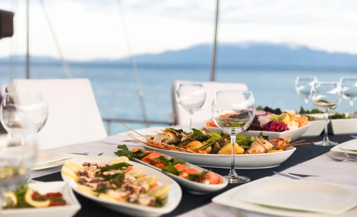Estrella De Mar luxury yacht charter table set with plates and drinks at sunset