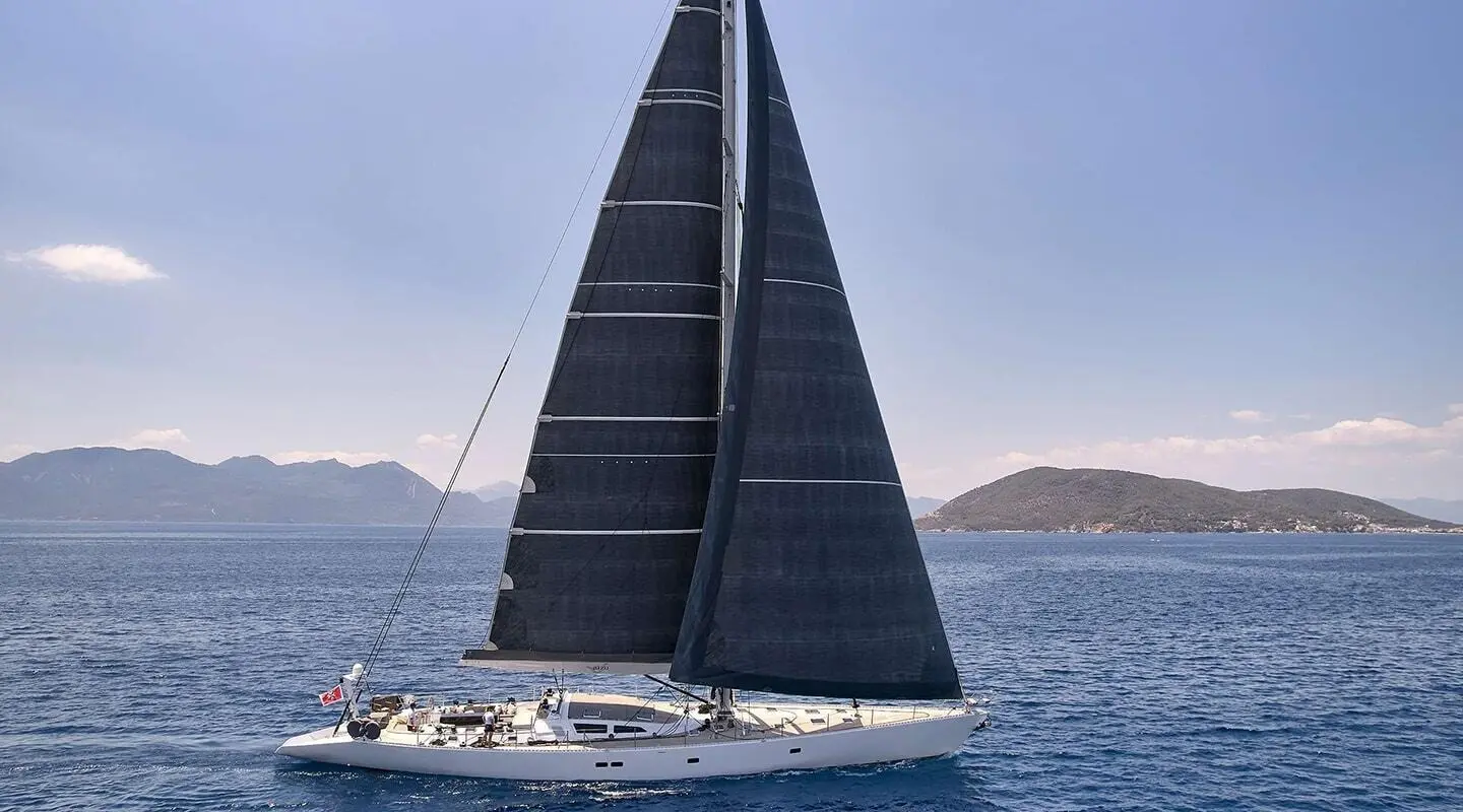 Aizu luxury sailing yacht with black sails slicing through blue sea