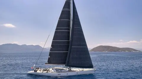 Aizu luxury sailing yacht with black sails slicing through blue sea