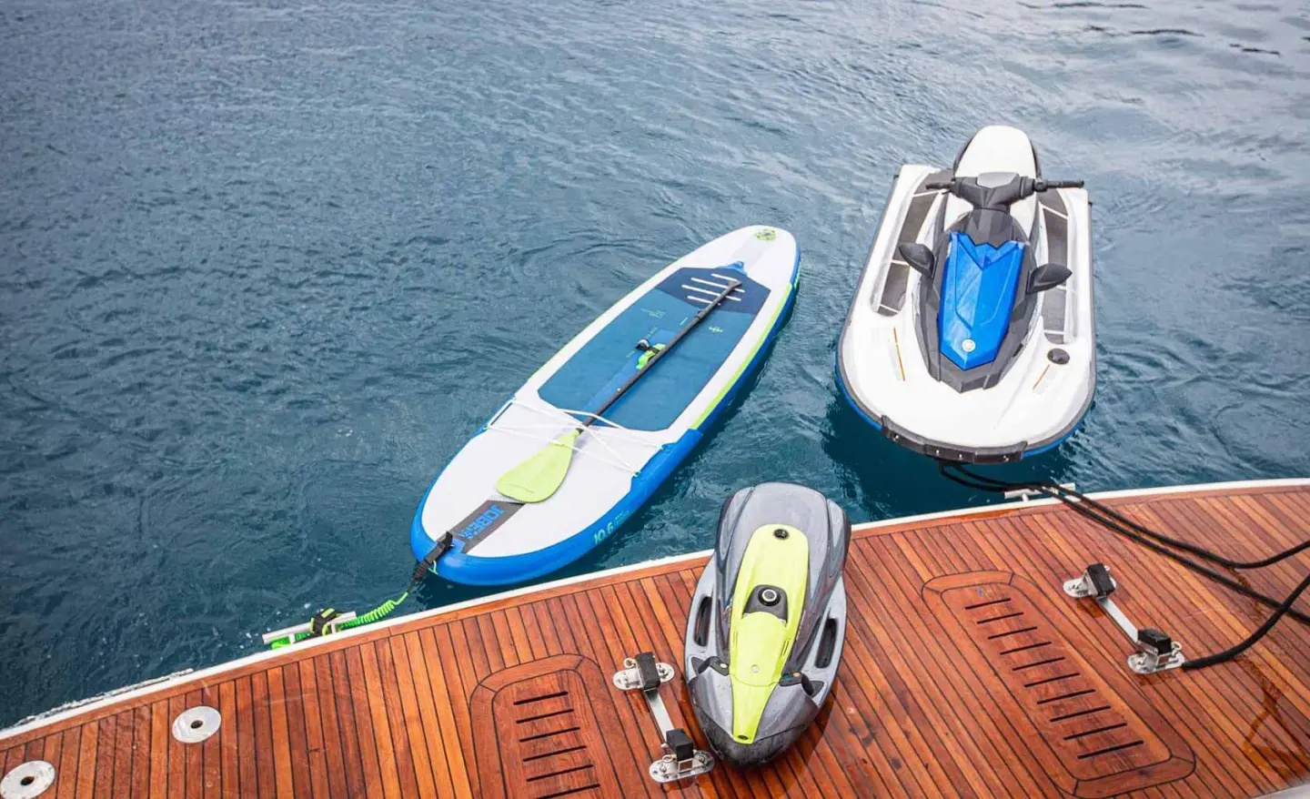 Yacht Insieme docked with blue and white dinghy on water at pier