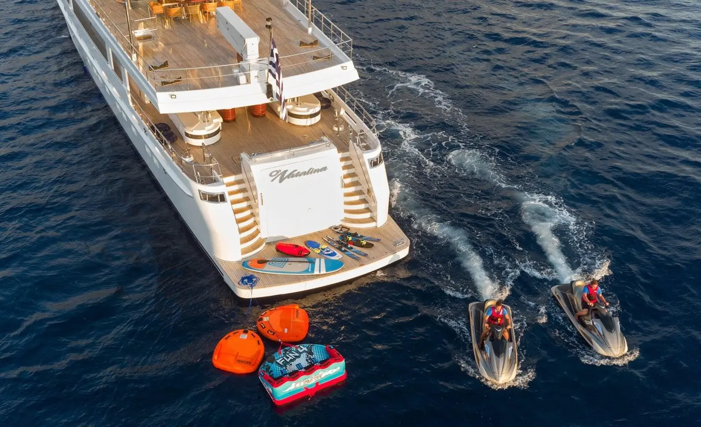 O'Natalina yacht at sunset with passengers on deck and small boat nearby