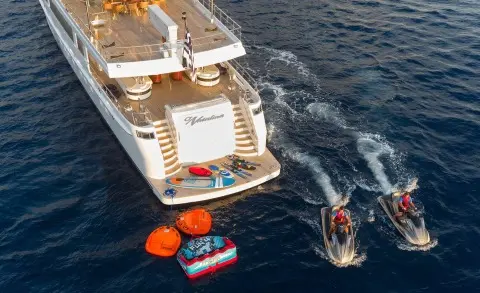 O'Natalina yacht at sunset with passengers on deck and small boat nearby