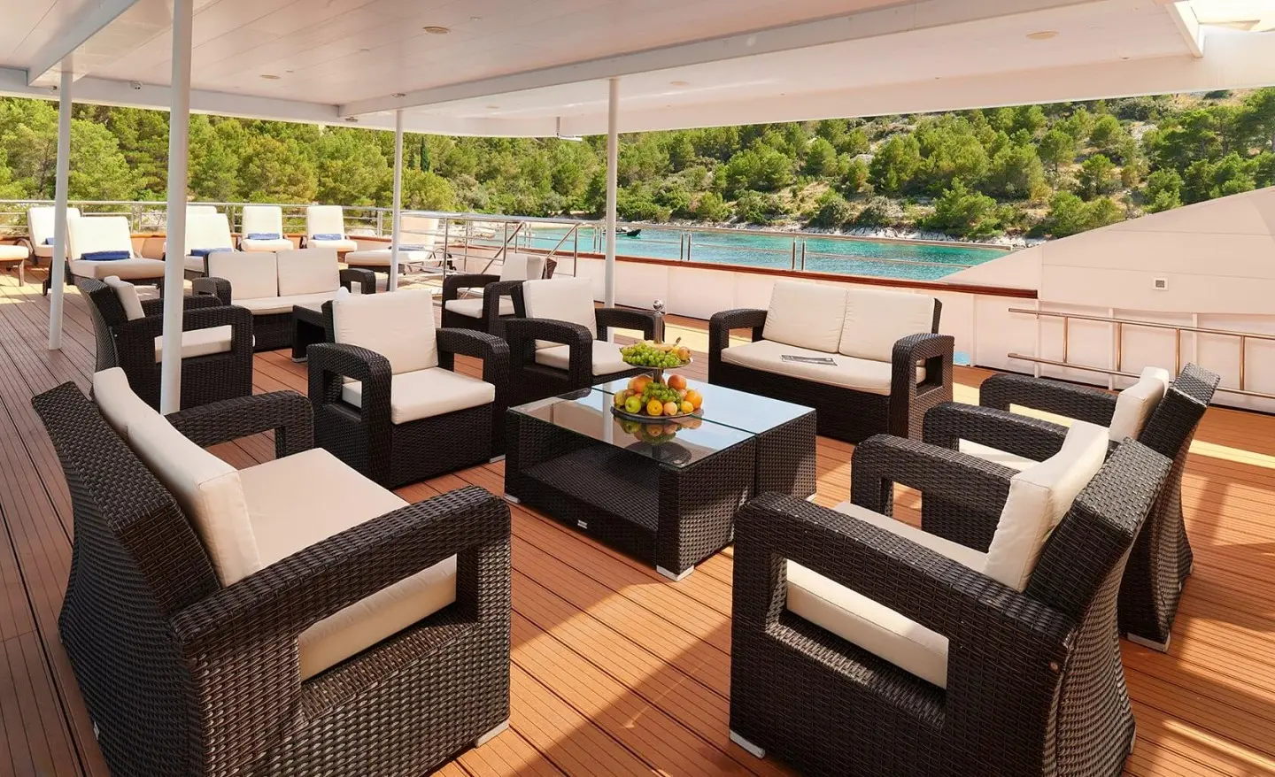 Queen Eleganza upper deck seating area at sunset on luxury yacht, wicker chairs