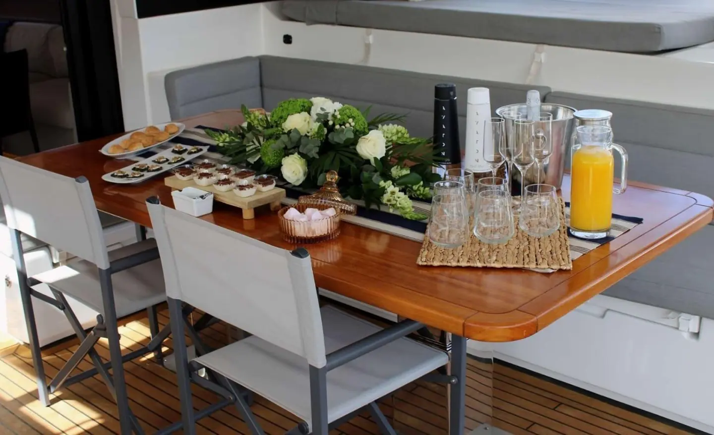 Yacht Atlantis dining table on deck with flowers, glassware, and plates