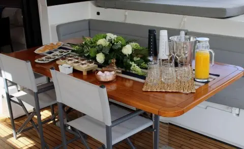 Yacht Atlantis dining table on deck with flowers, glassware, and plates