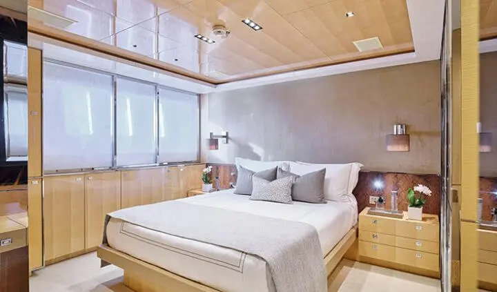 La Pellegrina 1 master cabin with king bed, beige bedding, wooden ceiling, and windows