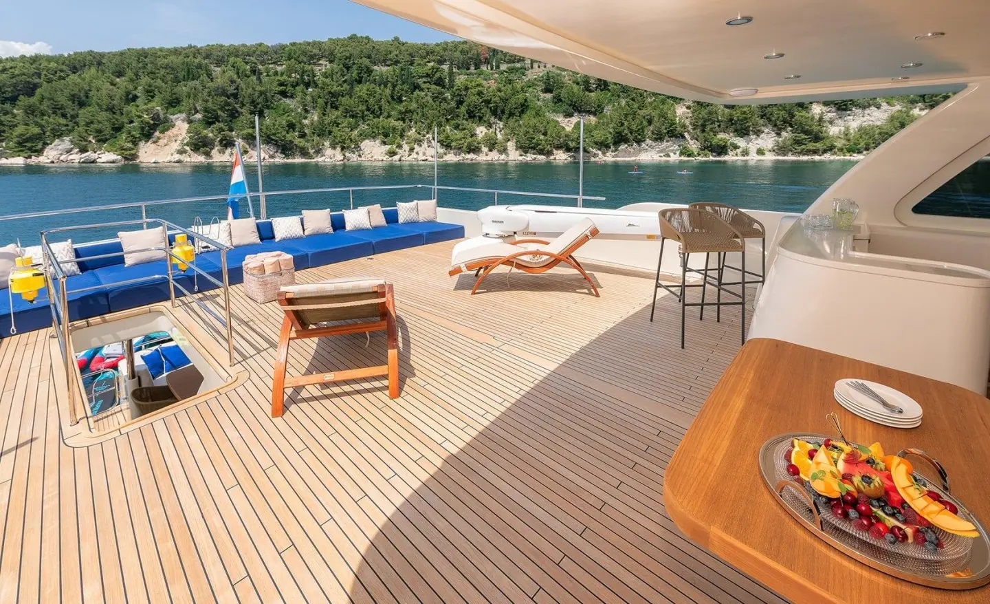 Deck of Grace yacht with cushioned seating, wooden table, and ocean view