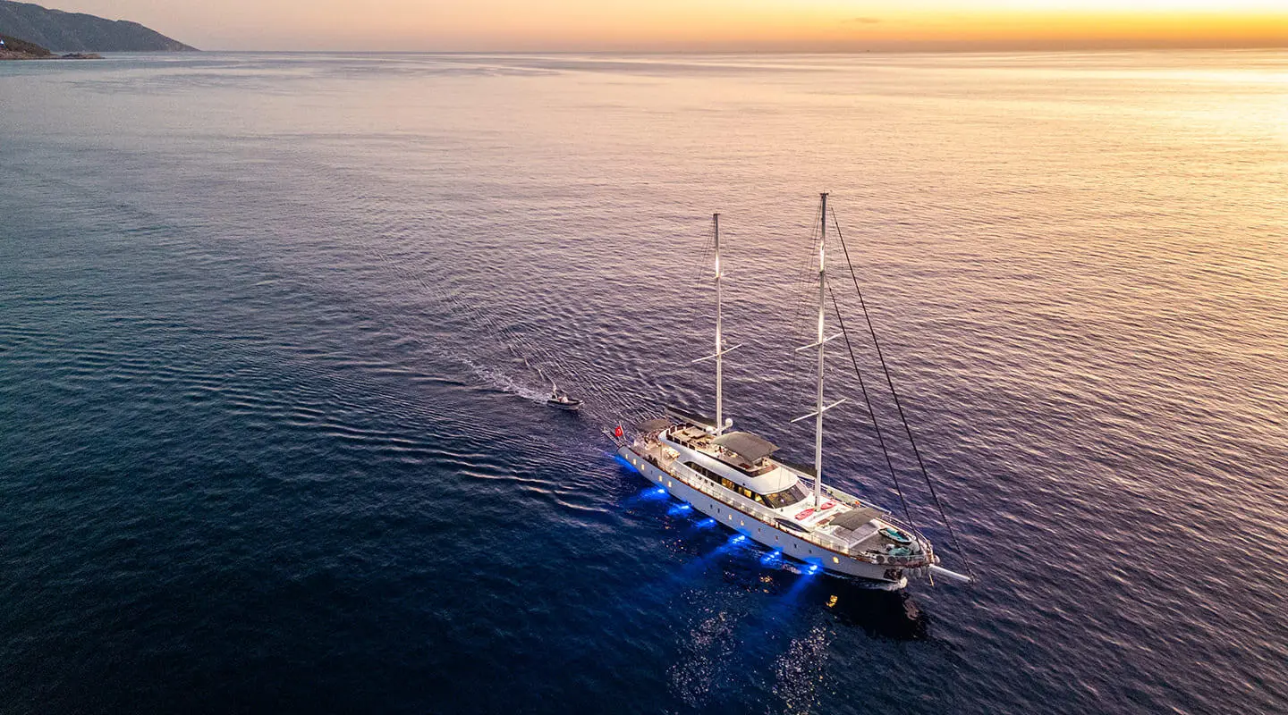 Queen Of Makri yacht anchored near sunset with sails and calm sea
