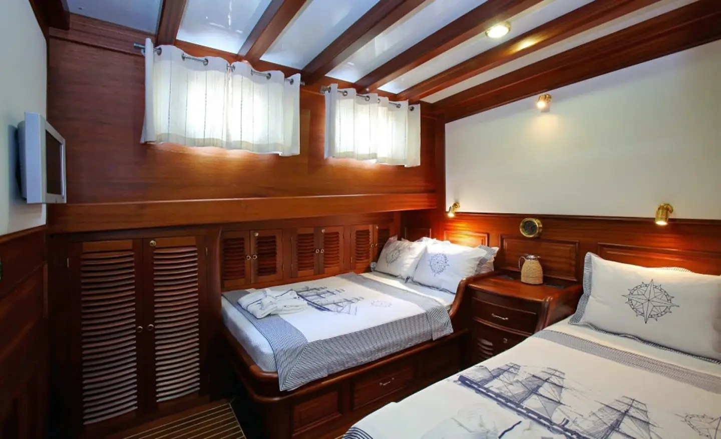 Kaya Guneri 4 yacht interior with two single beds and wooden paneling at sunset