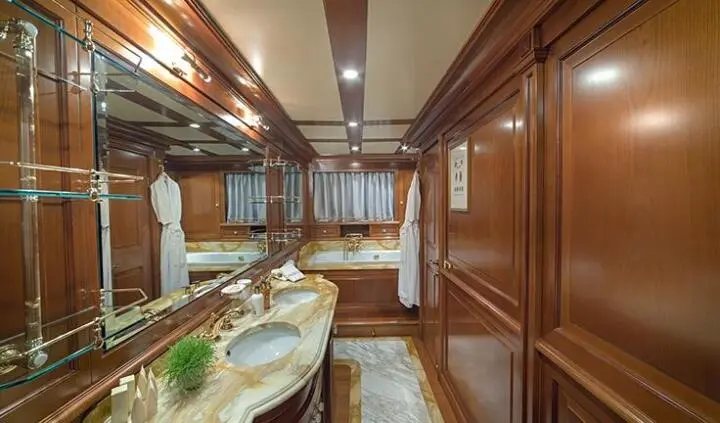 Aquila yacht master cabin with king bed and ensuite bathroom, wood paneling