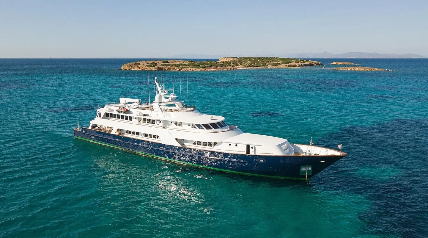 Luxurious Wind Of Fortune yacht anchored offshore at sunset, calm blue sea