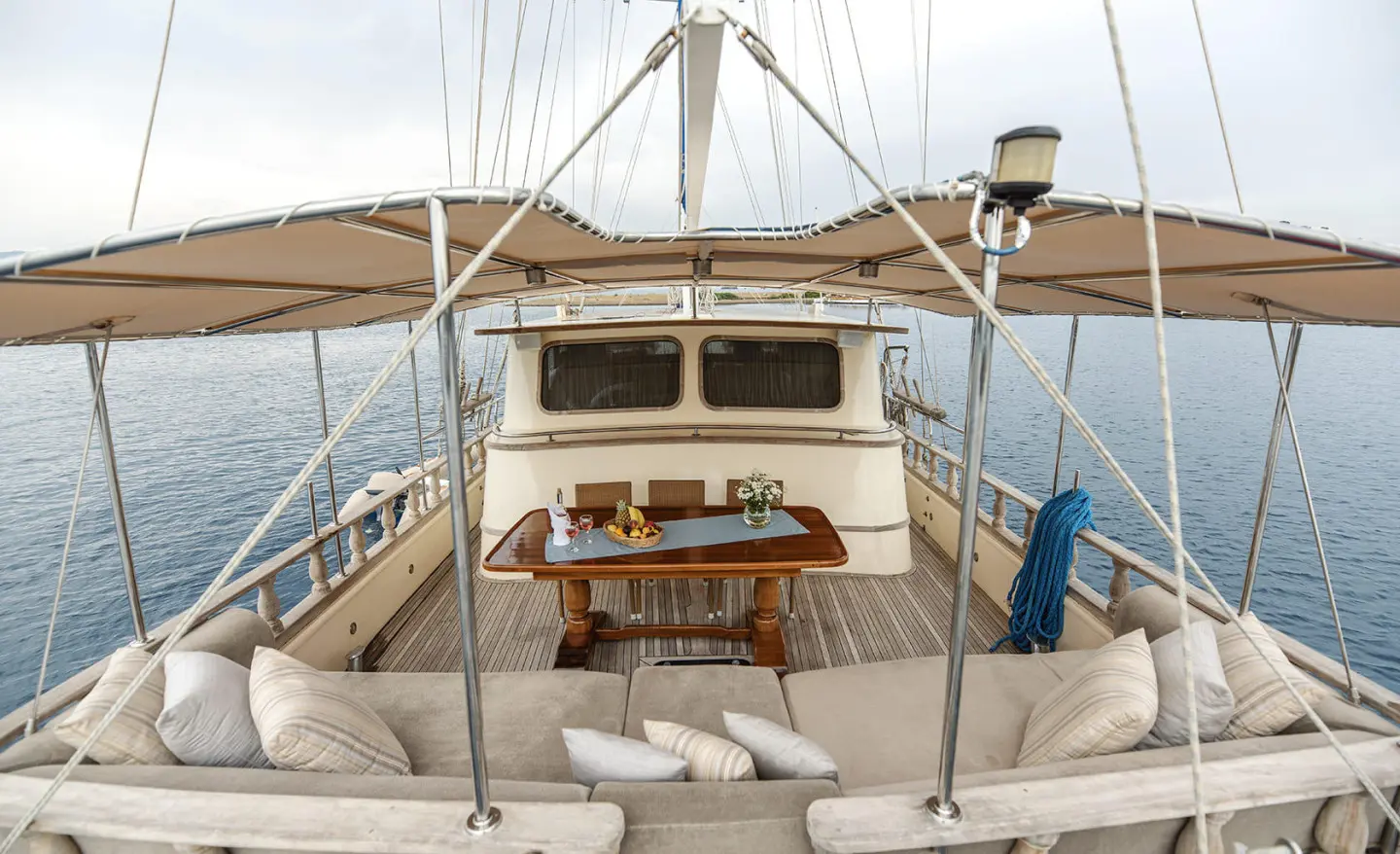 Gulet Faralya aft deck view with wheel, seating, blue hulls, and rigging