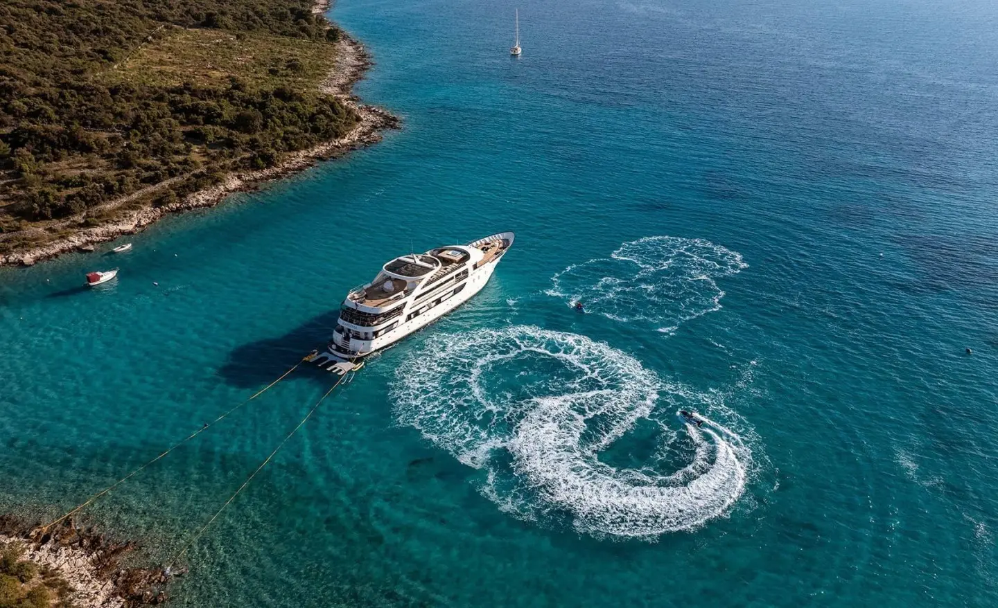 Karizma yacht cruising azure sea; small wake around stern in clear water