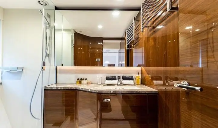 View of a yacht cabin vanity with sink, mirror, and wooden cabinetry