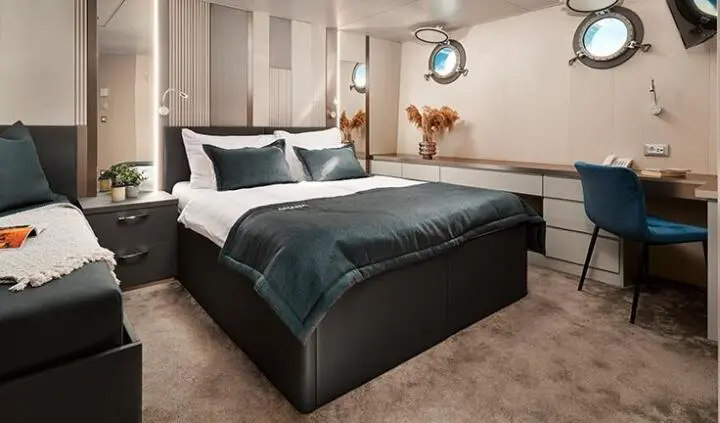 Master cabin with king bed, dark bedding, and en-suite area visible
