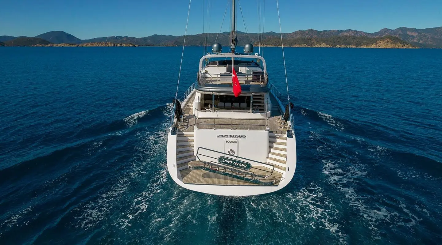 Aerial view of a luxury yacht named Long Island anchored in blue water at sunset
