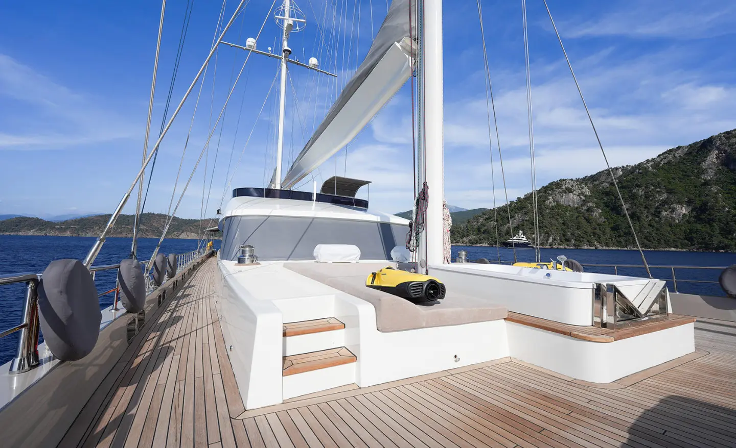 Sunlit deck of King Of The Sea yacht with white rails and calm harbor view
