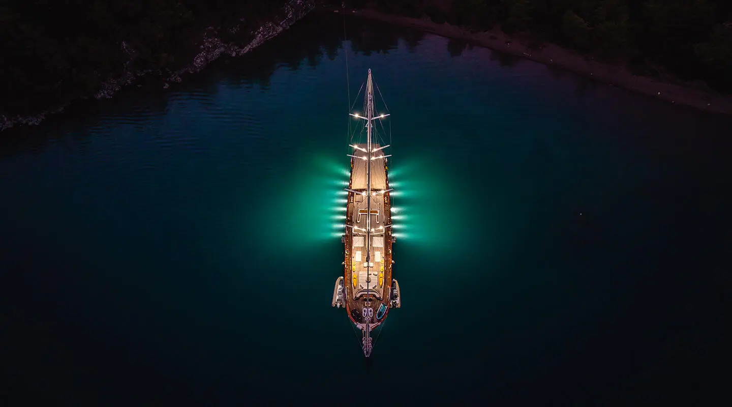 Night-lit gulet La Bella Vita afloat in dark water with deck lights