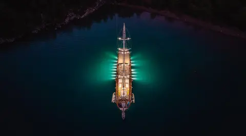 Night-lit gulet La Bella Vita afloat in dark water with deck lights