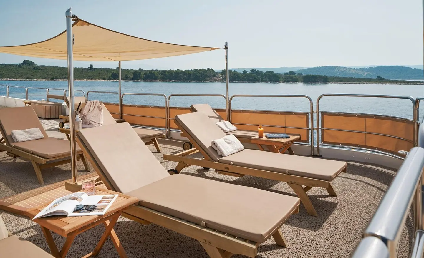 La Perla yacht deck with sun loungers and shade sail overlooking water