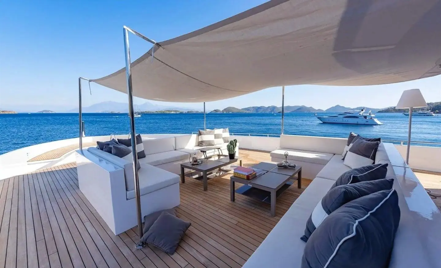 Ocean Breeze yacht deck with shaded seating area and blue sea in background