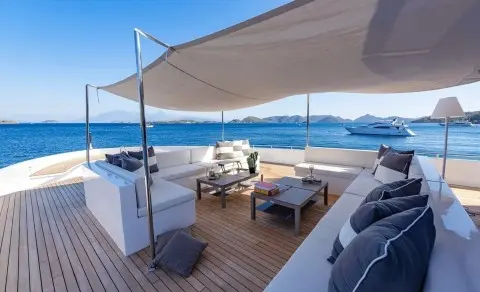 Ocean Breeze yacht deck with shaded seating area and blue sea in background
