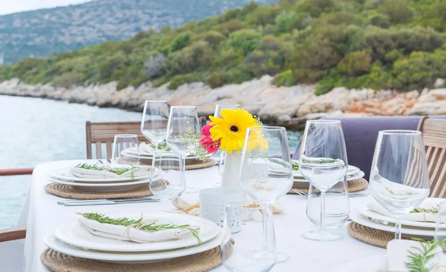Primadonna yacht at sunset with dining setup on deck umbrellas and flowers