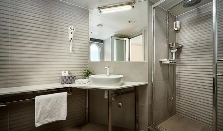 Master cabin with king bed, ensuite bathroom and vanity in yacht Ohana